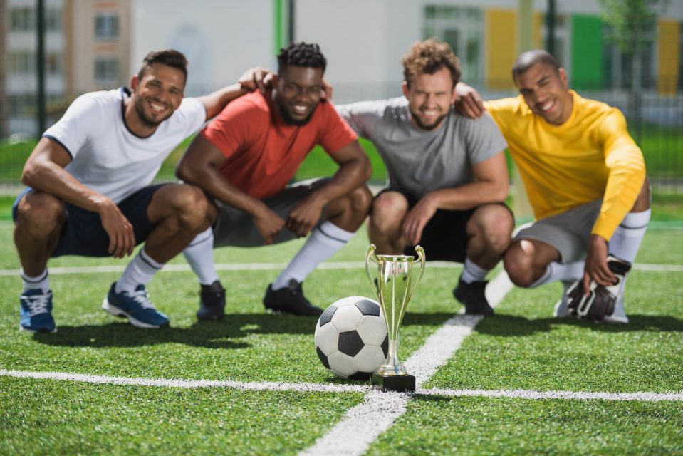 smiling-multiethnic-soccer-team-with-goblet-on-soc-2022-02-07-11-37-27-utc